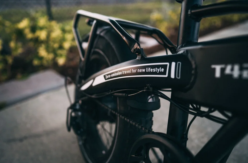 Rear wheel and frame detail of a black electric bicycle; lifestyle imagery, not a catalogue product